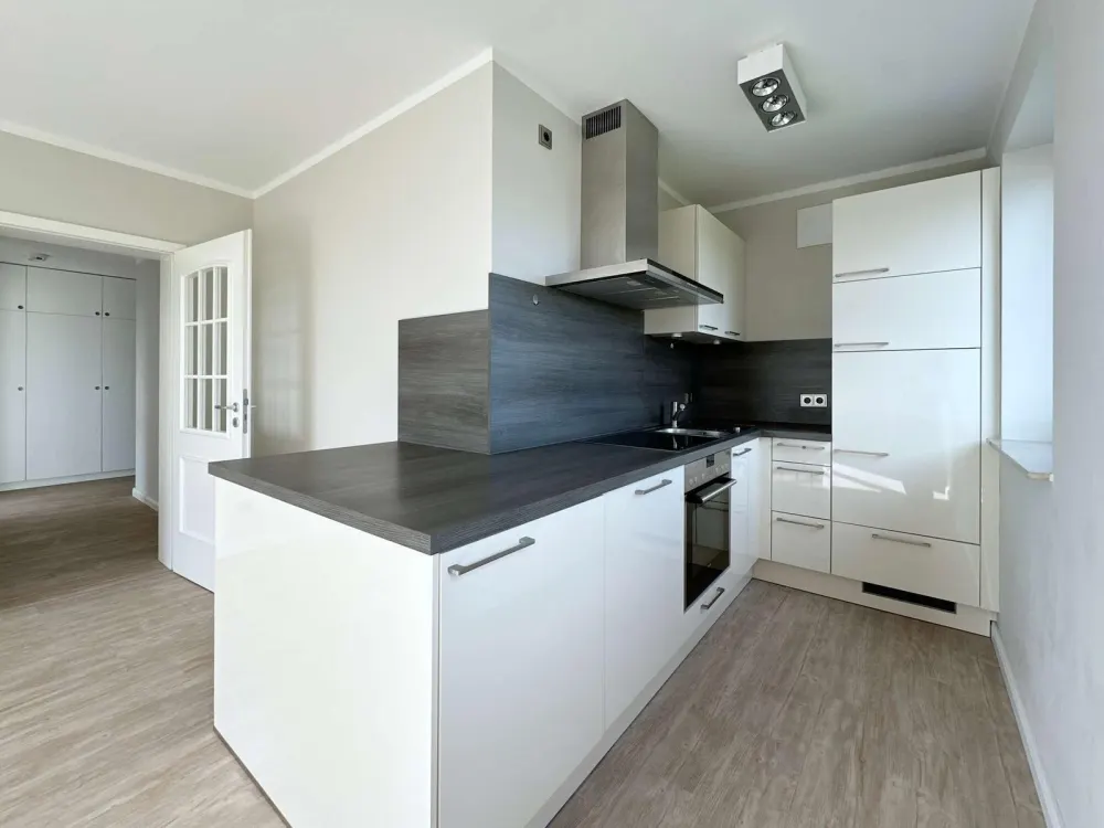 High-quality renovated 2-room apartment with fitted kitchen, balcony, elevator & underground parking space