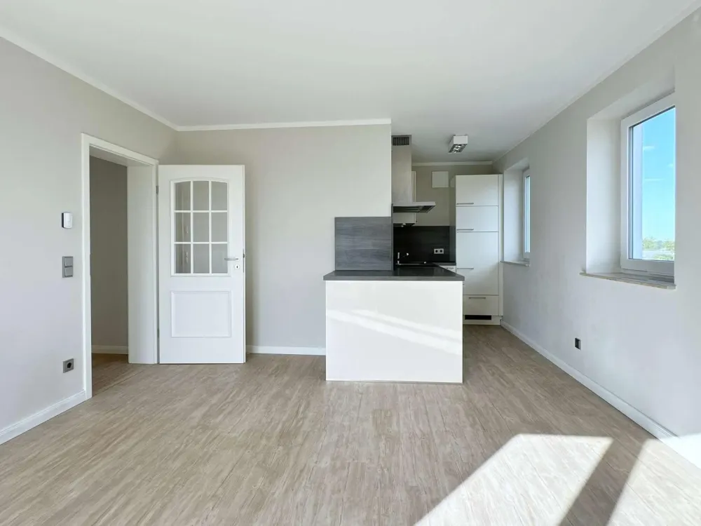High-quality renovated 2-room apartment with fitted kitchen, balcony, elevator & underground parking space